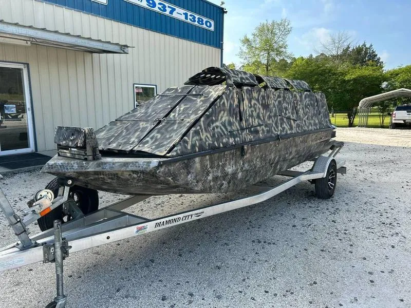 Slide: The Image of 2018 Excel F4 Pro Hull 1854 boat with camouflage design on a trailer. - 2