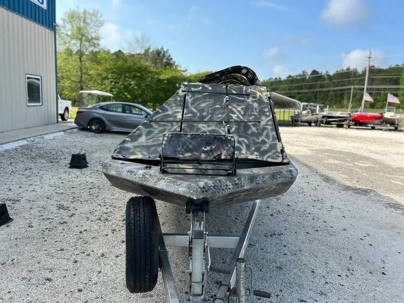 Slide: The Image of 2018 Excel F4 Pro Hull 1854 boat on trailer, camo design, outdoor setting. - 4
