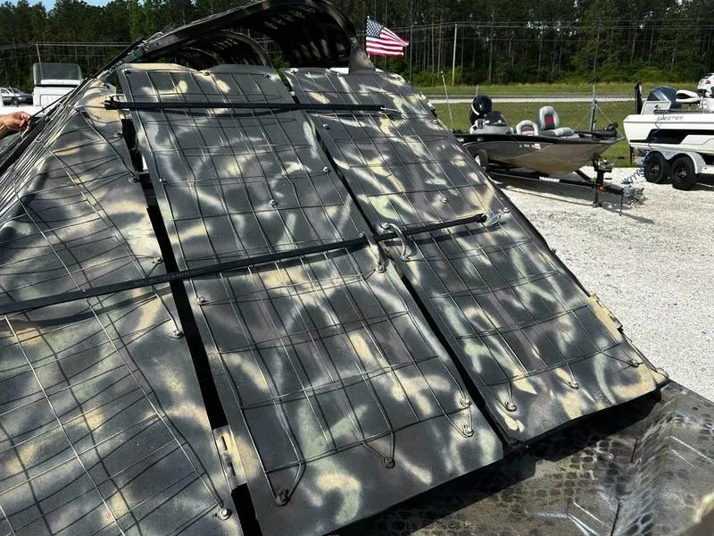 Slide: The Image of Camouflage-patterned Excel F4 Pro Hull 1854 boat, 2018 model, with American flag in background. - 9