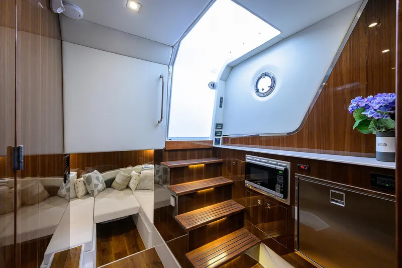 Slide: The Image of 2024 Cruisers Yachts GLS-OB interior with modern wood finish and cozy seating area. - 21