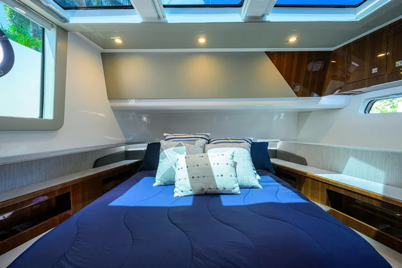 Slide: The Image of Luxurious cabin interior of 2024 Cruisers Yachts GLS-OB with skylight and plush bedding. - 24
