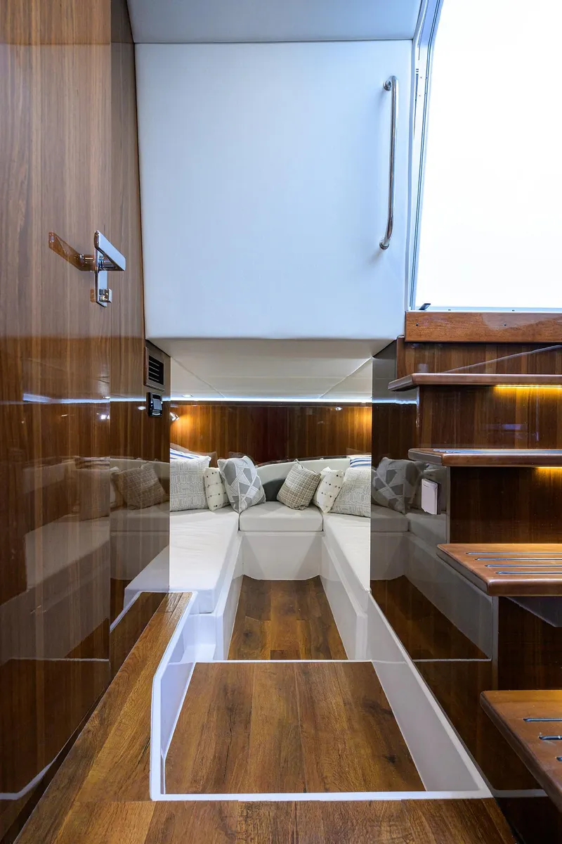 Slide: The Image of 2024 Cruisers Yachts GLS-OB interior with modern wood finish and cozy seating area. - 29