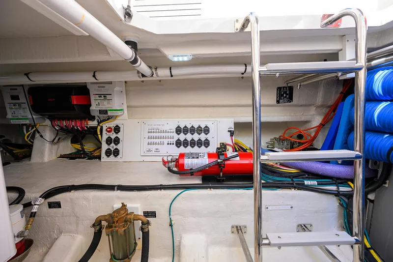 Slide: The Image of 2024 Cruisers Yachts GLS-OB engine room with control panel, wiring, and fire extinguisher. - 39