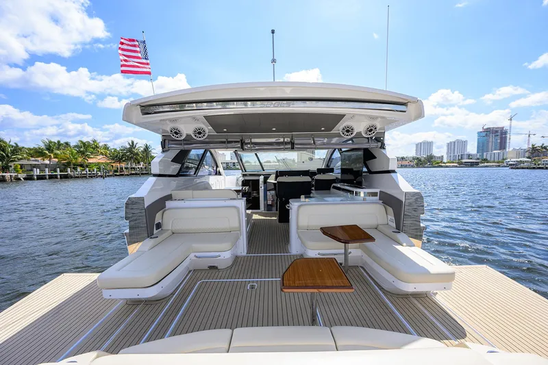 Slide: The Image of 2024 Cruisers Yachts GLS-OB on water, featuring luxurious seating and American flag. - 7