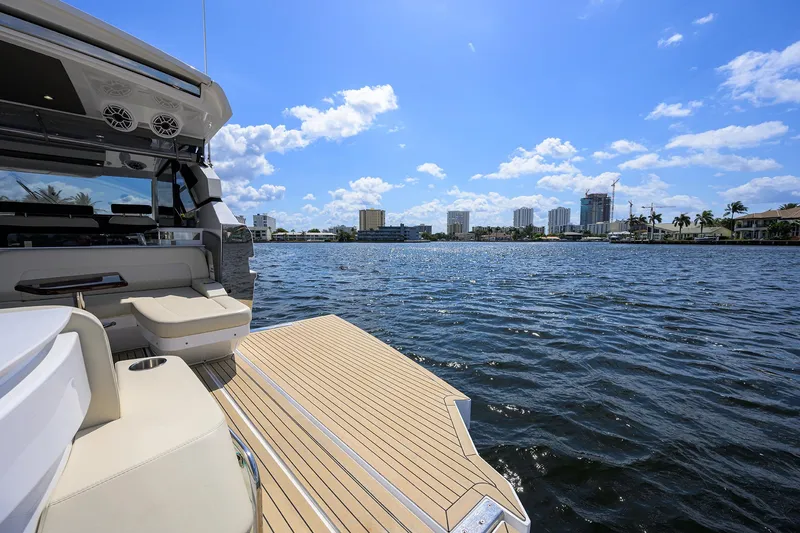 Slide: The Image of 2024 Cruisers Yachts GLS-OB on water, sunny day, city skyline in background. - 8