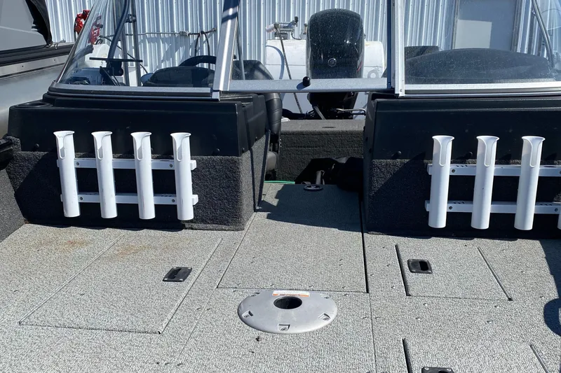 Slide: The Image of 2021 Crestliner FishHawk 1650 boat interior with rod holders and seating area. - 4