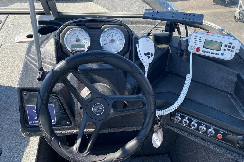 Slide: The Image of 2021 Crestliner FishHawk 1650 dashboard with steering wheel, gauges, and communication equipment. - 8