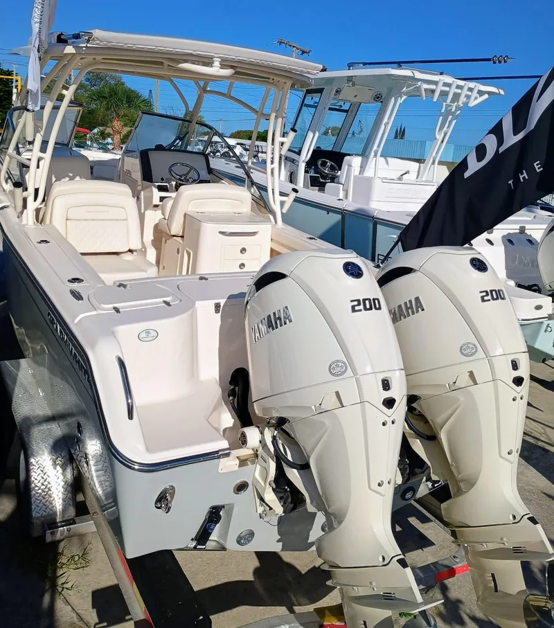 Slide: The Image of 2025 Grady-White Freedom 275 boat with twin Yamaha 200 engines, docked outdoors. - 24