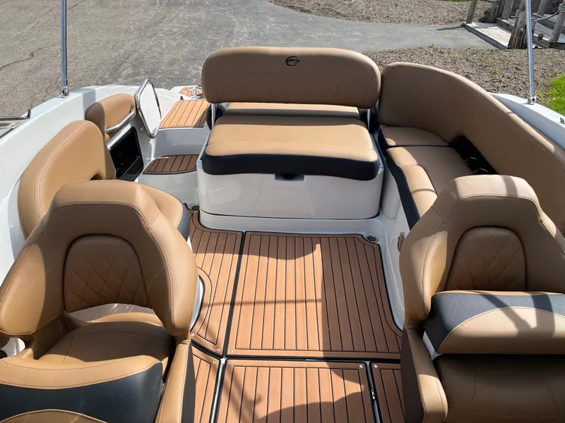 Slide: The Image of 2025 Crownline Eclipse E235 boat interior with tan seating and wood-style flooring. - 10