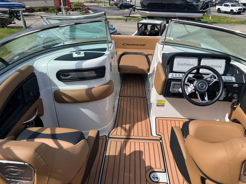 Slide: The Image of 2025 Crownline Eclipse E235 boat interior with tan seating and modern dashboard. - 11