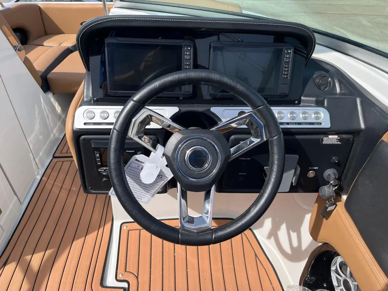 Slide: The Image of 2025 Crownline Eclipse E235 boat dashboard with steering wheel and digital displays. - 16