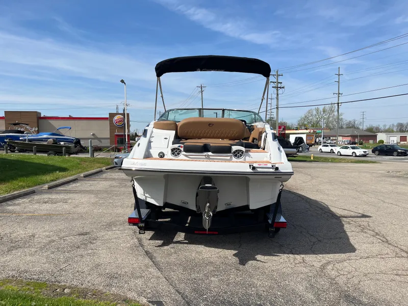 Slide: The Image of 2025 Crownline Eclipse E235 boat parked outdoors on a sunny day. - 2