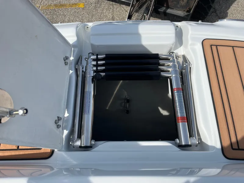Slide: The Image of 2025 Crownline Eclipse E235 boat ladder compartment with open hatch. - 6
