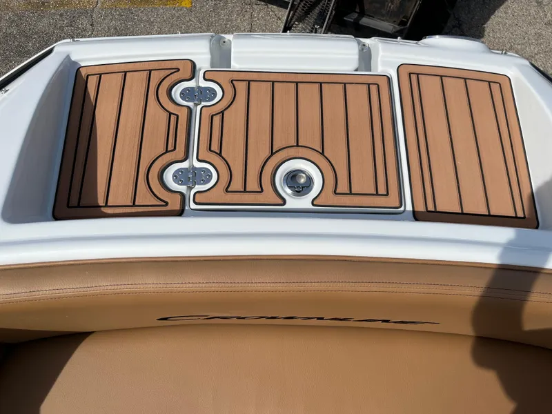 Slide: The Image of 2025 Crownline Eclipse E235 boat deck with wood finish and tan seating. - 7