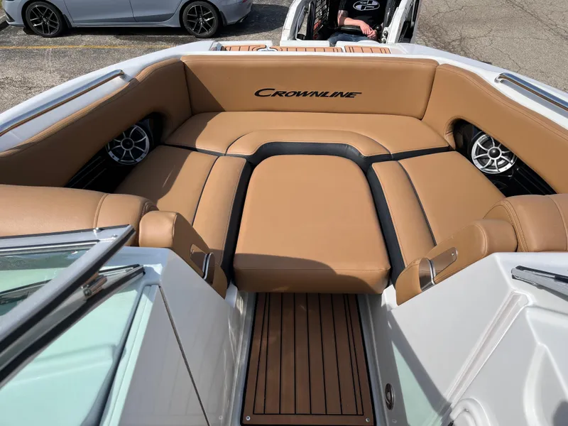 Slide: The Image of 2025 Crownline Eclipse E235 boat interior with tan seating and wood flooring. - 8