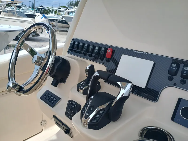 Slide: The Image of 2025 Grady-White Canyon 271 boat dashboard with steering wheel and controls. - 15