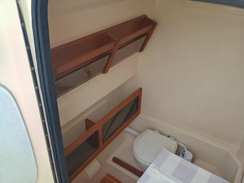 Slide: The Image of Interior of 2025 Grady-White Canyon 271 boat with compact bathroom amenities. - 23