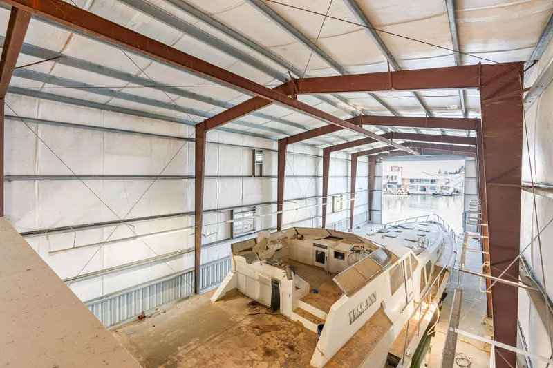 Slide: The Image of 1985 Custom Larson Boathouse interior with large boat docked inside. - 10