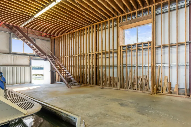 Slide: The Image of Spacious 1985 Custom Larson Boathouse interior with wooden beams and staircase. - 12