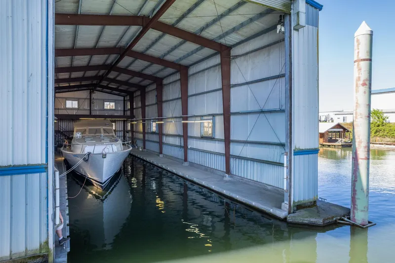 Slide: The Image of Custom 1985 Larson Boathouse with docked boat in sheltered marina setting. - 17