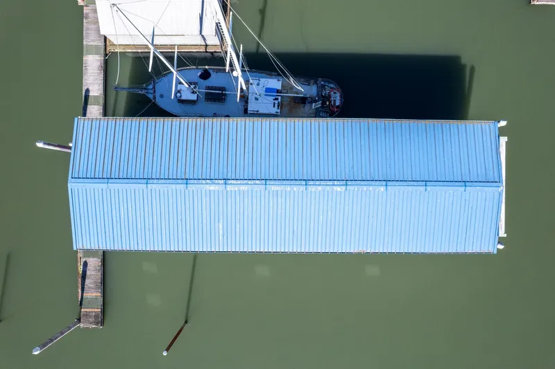 Slide: The Image of Aerial view of 1985 Custom Larson Boathouse with sailboat docked underneath. - 18