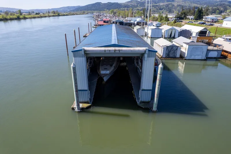 Slide: The Image of Aerial view of 1985 Custom Larson Boathouse on a serene river. - 21