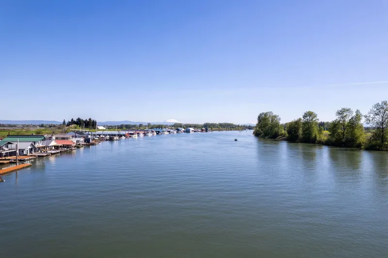 Slide: The Image of Wide river view with boathouses and trees under clear blue sky, Larson Boathouse, 1985. - 24