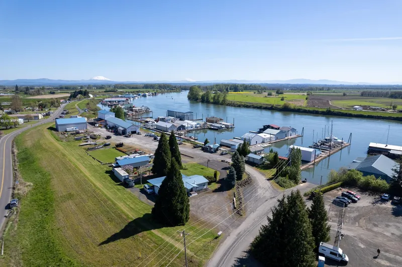 Slide: The Image of Aerial view of Larson Boathouse, 1985, by a scenic river with surrounding greenery. - 26