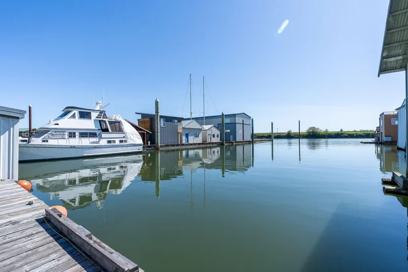 Slide: The Image of Calm marina view with a Custom 1985 Larson Boathouse and docked yacht. - 32