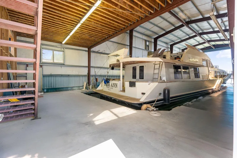 Slide: The Image of 1985 Custom Larson Boathouse with boat docked inside spacious indoor marina. - 6