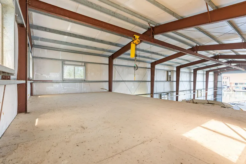 Slide: The Image of Spacious interior of 1985 Custom Larson Boathouse with metal beams and large windows. - 9