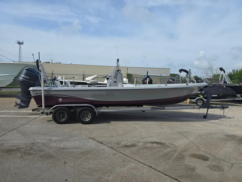 Slide: The Image of 2016 Blue Wave 2400 PureBay boat on trailer, parked outdoors. - 2