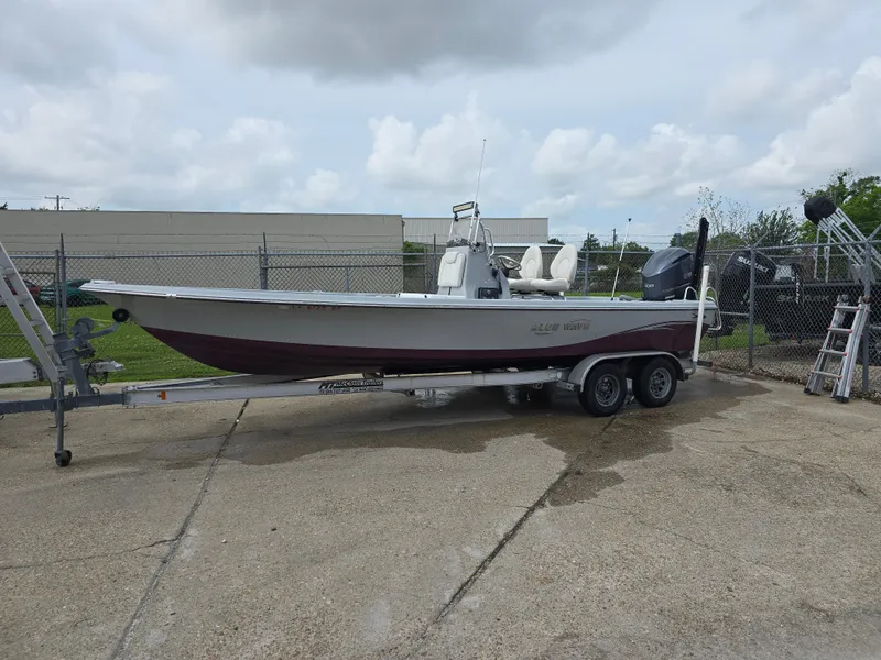 Slide: The Image of 2016 Blue Wave 2400 PureBay boat on trailer, parked outdoors under cloudy sky. - 3