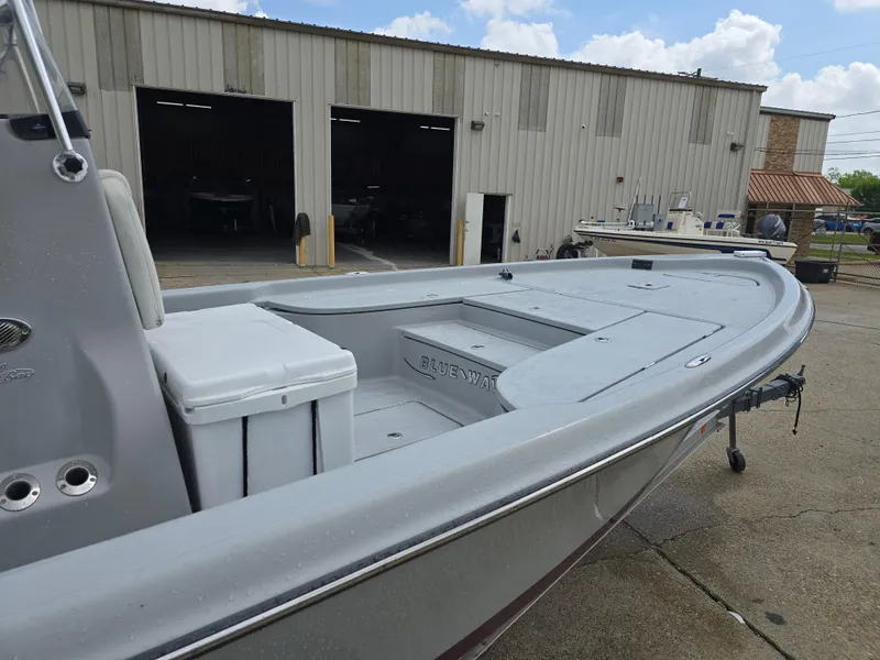 Slide: The Image of 2016 Blue Wave 2400 PureBay boat docked near a warehouse on a sunny day. - 8