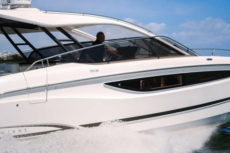 Slide: The Image of 2023 Four Winns TH36 OB boat cruising on water, side view. - 10