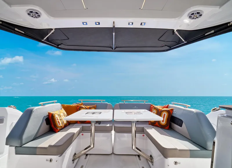 Slide: The Image of 2023 Four Winns TH36 OB yacht interior with ocean view, featuring seating and tables. - 11