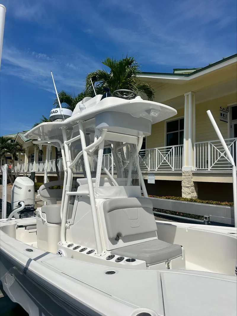 Slide: The Image of 2024 SeaVee 270Z boat with center console, docked near a building under a clear blue sky. - 3