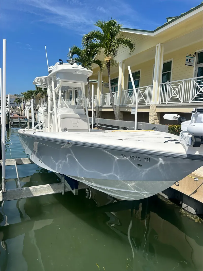 Slide: The Image of 2024 SeaVee 270Z boat docked near a waterfront building under a clear blue sky. - 6