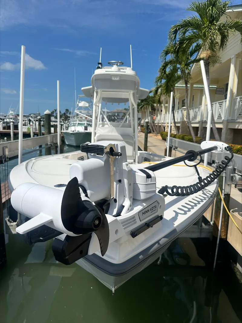 Slide: The Image of 2024 SeaVee 270Z boat docked, featuring a trolling motor, under clear blue skies. - 8