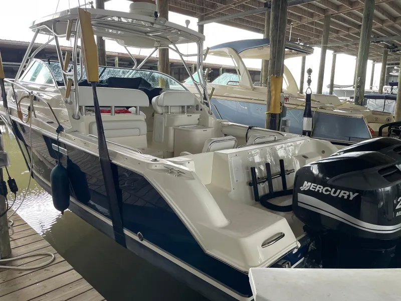 Slide: The Image of 2004 Wellcraft 290 Coastal boat docked with Mercury outboard engine. - 10