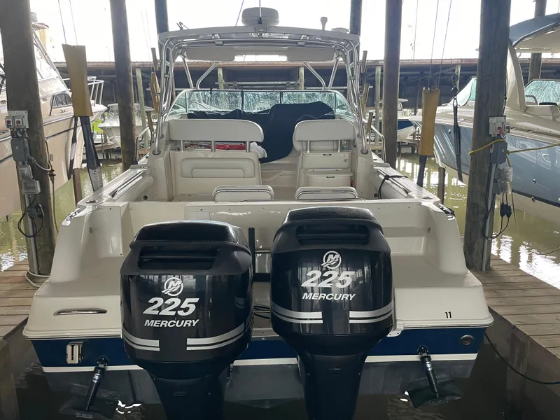 Slide: The Image of 2004 Wellcraft 290 Coastal boat with twin 225 Mercury engines docked in a marina. - 12