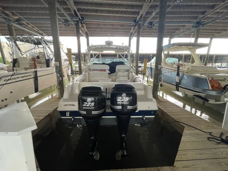 Slide: The Image of 2004 Wellcraft 290 Coastal boat with twin Mercury 225 engines docked in a marina. - 13