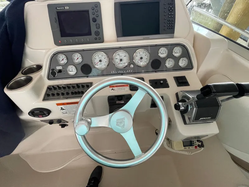 Slide: The Image of 2004 Wellcraft 290 Coastal helm with gauges, steering wheel, and navigation equipment. - 19