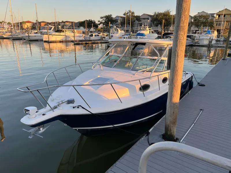 Slide: The Image of 2004 Wellcraft 290 Coastal boat docked in a serene marina setting. - 3