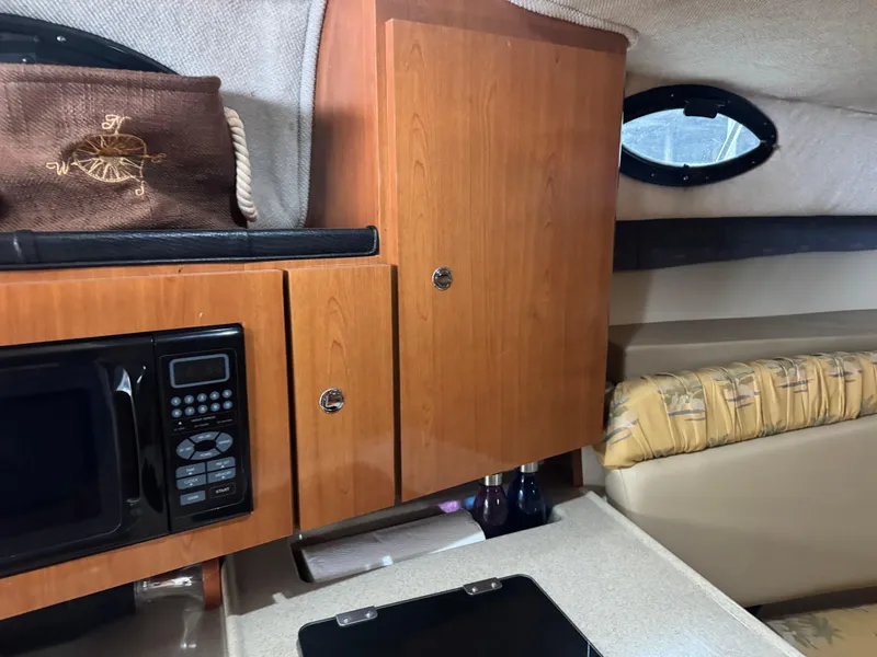 Slide: The Image of 2004 Wellcraft 290 Coastal cabin interior with microwave, cabinets, and seating area. - 35