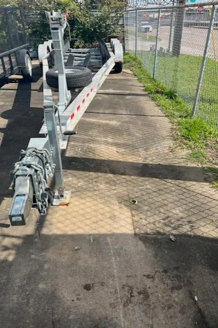 Slide: The Image of Trailer for 2004 Wellcraft 290 Coastal boat parked on paved area near chain-link fence. - 43