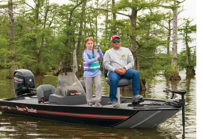 Slide: The Image of 2024 Tracker BASS TRACKER® Classic XL boat with two people fishing in a scenic lake. - 5