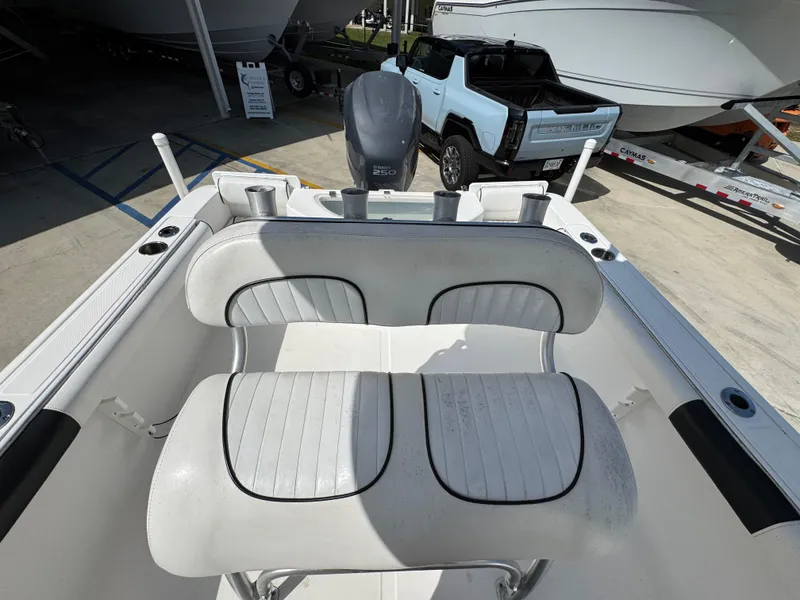 Slide: The Image of 2011 Sea Fox 236 Center Console boat interior with seating and motor, parked near a vehicle. - 31