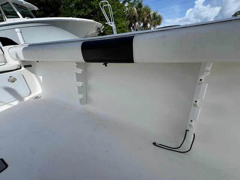 Slide: The Image of 2011 Sea Fox 236 Center Console boat interior with rod holders and clean white deck. - 35