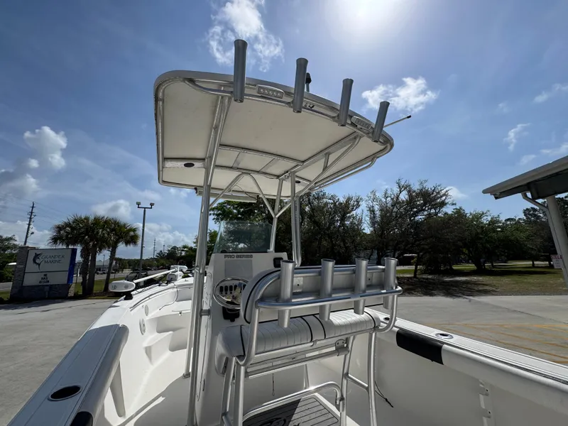 Slide: The Image of 2011 Sea Fox 236 Center Console boat with T-top and rod holders under a sunny sky. - 38